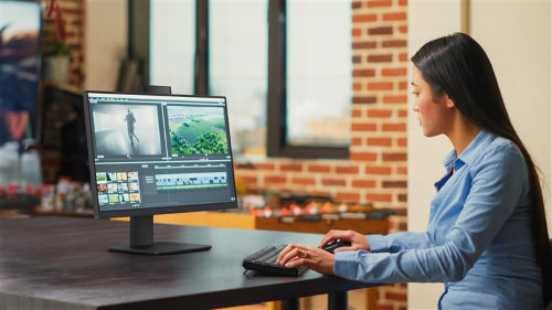 A woman sitting at a desk using an ASUS setup in an office setting